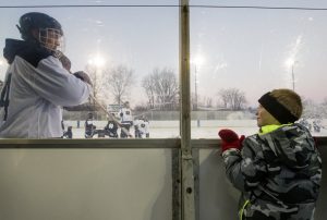 Notre Dame senior Thomas DiPauli interacts with Sam Hanson, 8, during Notre Dame Hockey's annual practice on the pond Monday, January 4, 2016 at Merrifield Park in Mishawaka.